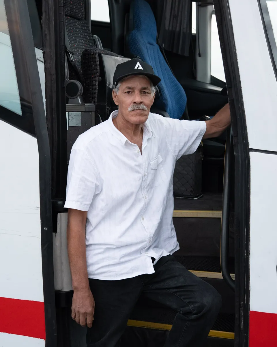 A bus driver in the doorway of his coach, unedited RAW